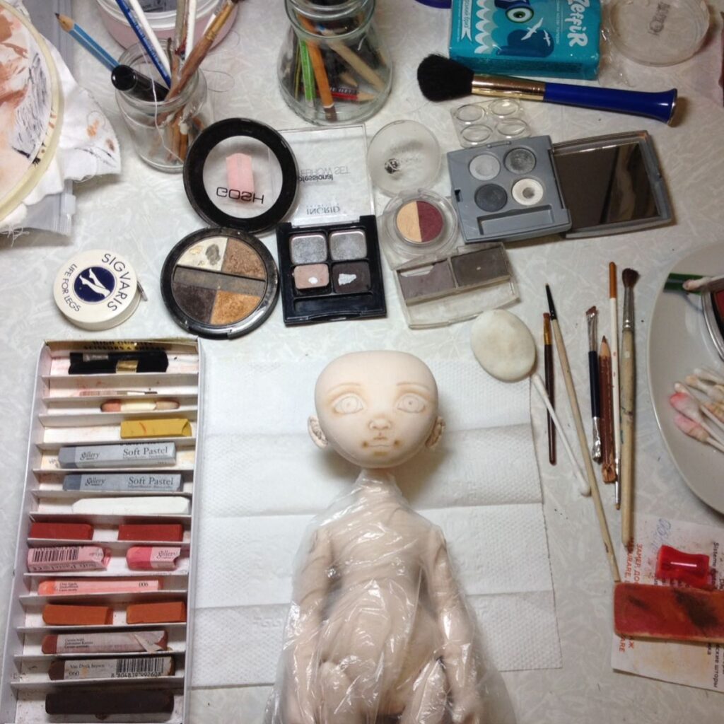Fabric doll face made with acrylic paint and pastel blush